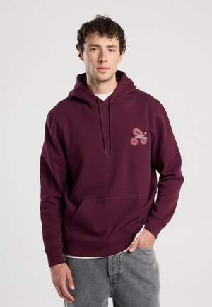 Bordeaux hoodie met een voorzak, capuchon met trekkoord en een grafisch element met de tekst "ROCKY MOUNTAINS" in lichte kleuren.