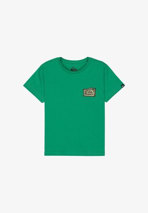 Vihreä lyhythihainen t-paita pyöreällä kaula-aukolla ja vasemmassa rintakehässä pieni beige kirjailtu merkki, jossa on geometrinen kuvio.