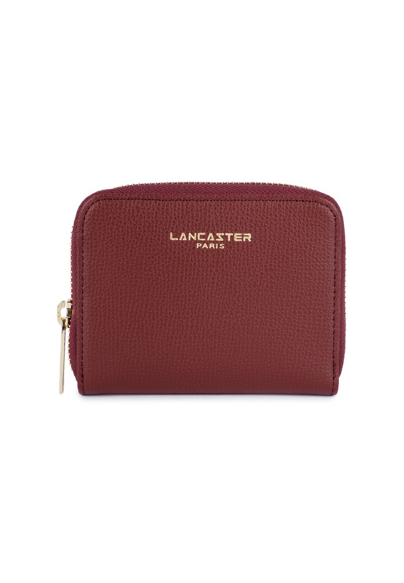 Bordeaux leren portemonnee met een gestructureerde afwerking, gouden logo aan de voorkant en een ritsluiting. Compacter rechthoekige vorm.