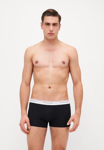 Boxers noirs avec une ceinture élastique blanche ornée du logo "DSQUARED2". Texture du tissu lisse ; coupe ajustée mettant en valeur la silhouette du modèle.