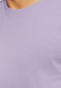 Jasnofioletowa bawełniana koszulka z okrągłym dekoltem i subtelnym logo s.Oliver haftowanym na piersi. Gładka tekstura i dopasowany krój.