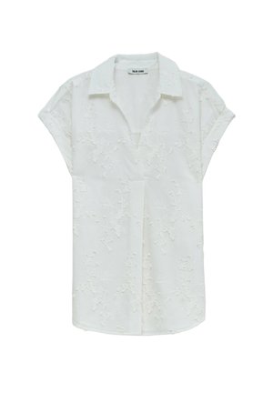 Blouse blanche à manches courtes avec broderies florales, un col classique, et une coupe décontractée avec un ourlet droit et des côtés légèrement fuselés.