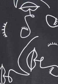 Tejido negro que presenta dibujos abstractos en líneas blancas de rostros y formas. Los diseños incluyen ojos, labios y formas similares a hojas.