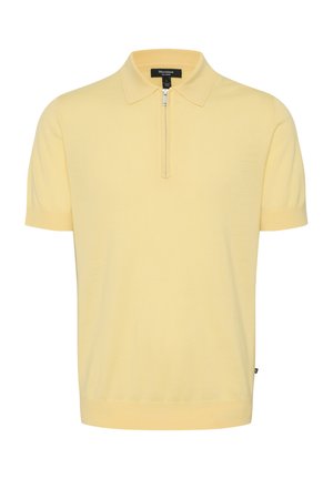 Lühikeste varrukatega polo särk heleses kollases, millel on veerandvetti tõmmatav lukustus, lame krae ja soonikkoes mansetid. Pehme, peenekoeline materjal.