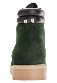 Zelené semišové kotníkové boty s černým koženým límcem a béžovou gumovou podrážkou. Obsahují pruhovaný akcent na límci a viditelné švy.