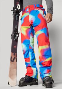 Pantalones de esquí coloridos con un patrón en espiral de rojo, azul y amarillo. Fabricados con material duradero, con cintura ajustable y bolsillos.