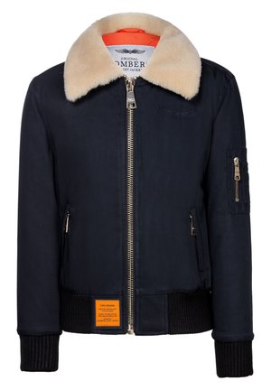 Marine bomberjack met een nepbontkraag, gouden rits, ribgebreide manchetten en een oranje voering. Heeft een oranje label aan de voorkant.