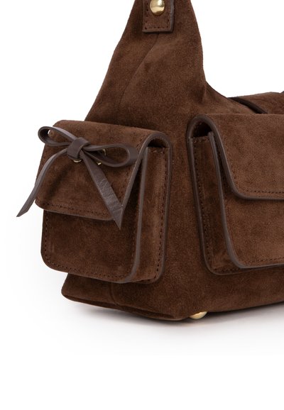 Brun ruskinds taske med læderdetaljer, to små frontlommer med sløjfedesign og guldfarvede metaldele i bunden.