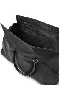 Svart läderresväska med texturerad yta, dubbla handtag och dragkedjetopp. Inuti finns en slät foder och en extra fack.