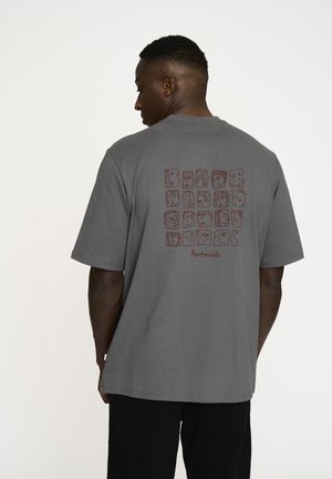 Grå bomulds T-shirt med et stort trykt grafisk motiv af ansigtet i mørkerød på ryggen, med en afslappet pasform og korte ærmer.