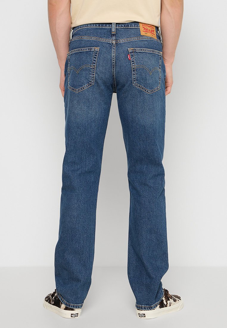 Lätta blå denimjeans med rak ben-design, synlig sömnad, två bakfickor och en läderlogotyp på midjebandet.