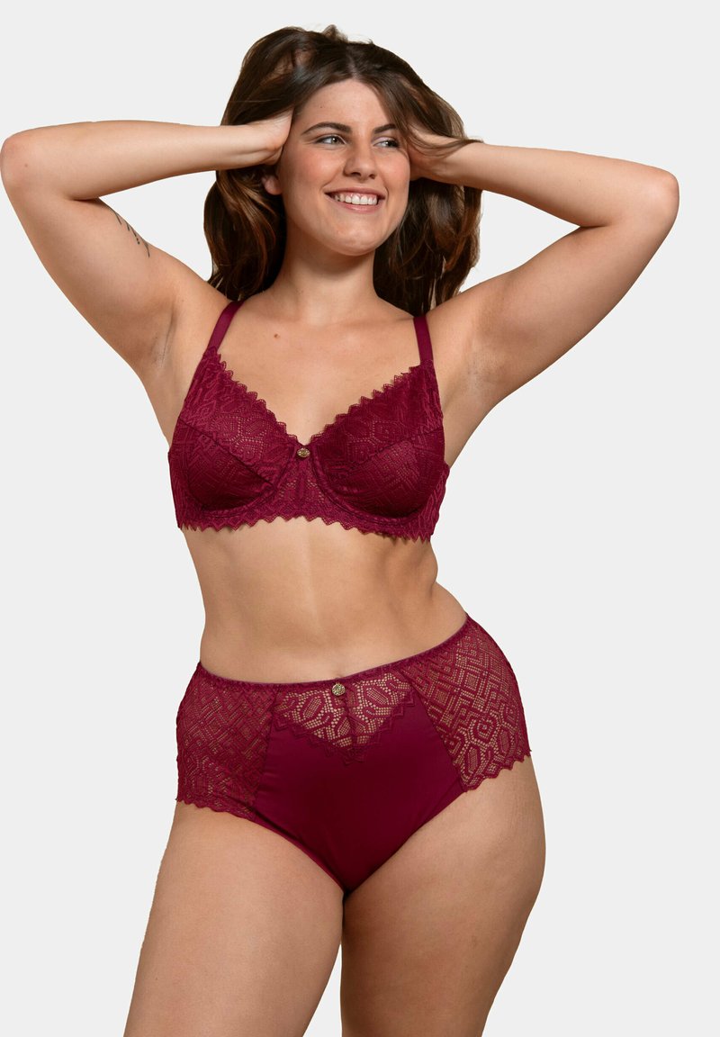 Soutien-gorge en dentelle bordeaux avec des bords festonnés et un détail de bouton, associé à des panties taille haute en dentelle et tissu avec des motifs géométriques.