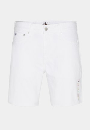 Bílé džínové šortky s rovnými nohavicemi, třepícím se lemem a vícebarevným vyšíváním "This is Love" na levé straně.