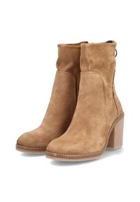 Bottines en daim marron avec talon bloc, dotées d'une fermeture éclair latérale et d'une texture lisse. La tige est doucement froncée près de la cheville.