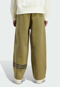 Olivově zelené kalhoty širokého střihu z měkké látky, s třemi tmavými pruhy na spodní straně a žebrovanými manžetami.