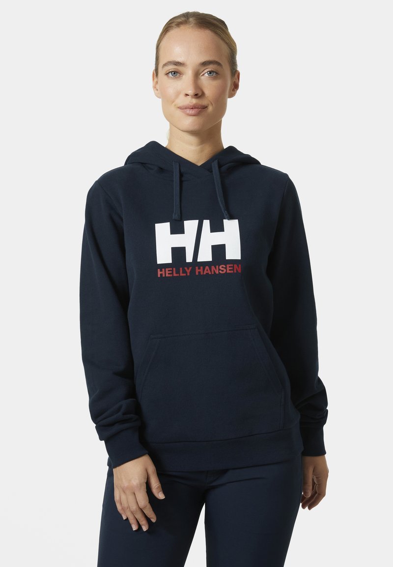 Námořnická modrá mikina s kapucí, přední klokaní kapsa a bílé logo "HH" nad nápisem "HELLY HANSEN" v červené barvě. Měkká látka s dlouhými rukávy.