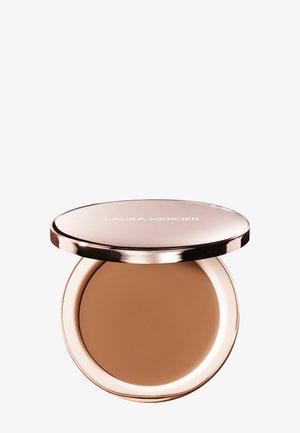 Ronde compacte Laura Mercier pressed powder foundation met een reflecterend gouden deksel, gedeeltelijk geopend zodat de bruine make-up van binnen zichtbaar is.