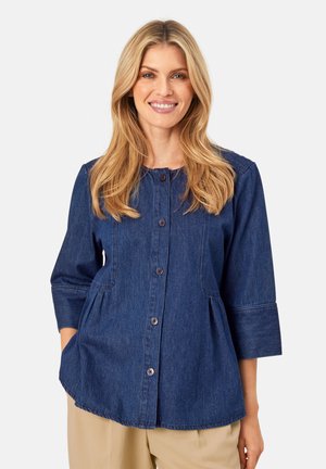 Denim skjorte, mørkeblå, knaplukning foran, trekvartærmer, afrundet nederkant, sidelommer, afslappet design, blød tekstur.