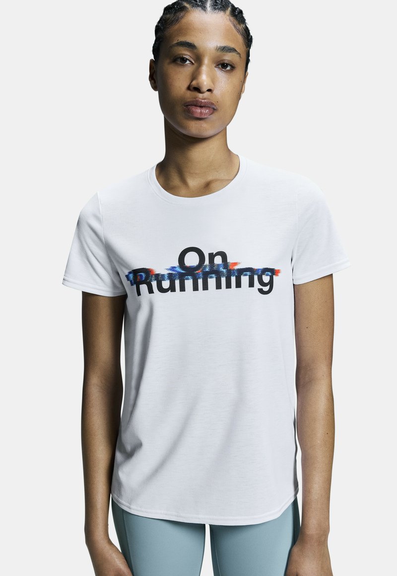 T-shirt blanc à manches courtes en tissu léger arborant un texte graphique noir et coloré "On Running" sur la poitrine. Encolure ronde.