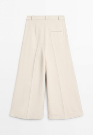 Hoch taillierte, cremefarbene, weit geschnittene Hose mit Gürtelschlaufen, umgeschlagenen Säumen und einer einzelnen Paspeltasche auf der Rückseite, flach auf einem weißen Hintergrund ausgelegt.