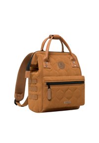 Gequilted tan rugzak met dubbele handgrepen en een verstelbare schouderriem. Voorzien van een voorvak met ritssluiting, een logo-patch, zilveren accenten en zijbanden.