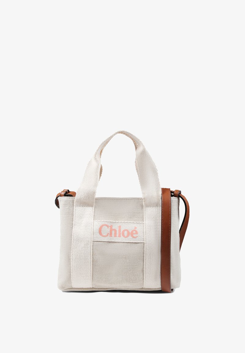 Sac en toile crème avec des accents en cuir marron et des poignées supérieures. Présente une patte frontale avec le logo "Chloé" en rose. Forme rectangulaire compacte.