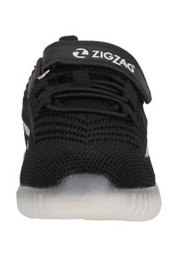 Sneaker in rete nera con suola in gomma bianca, dotata di una cinghia in Velcro e piccoli dettagli argentati sui lati, progettato per comfort e traspirabilità.