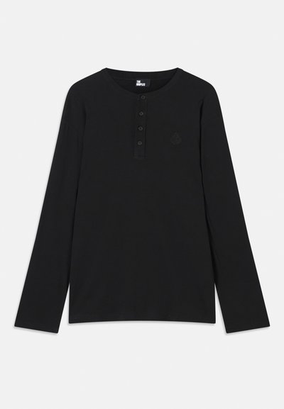 Čierna dlhá košeľa s dlhými rukávmi vyrobená z mäkkej tkaniny, s henley výstrihom a štyrmi gombíkmi a malým logom na hrudi.
