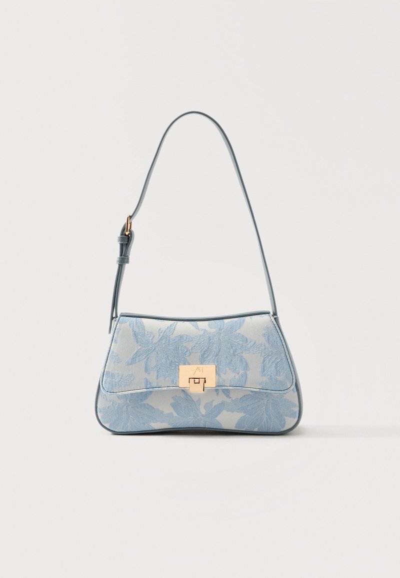 Μικρό μπλε τσαντάκι ώμου με λουλουδένιο μοτίβο και χρυσό κούμπωμα, σε απλό λευκό φόντο.