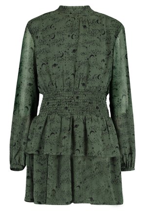 Zielona sukienka z marszczonym pasem, długimi rękawami i warstwowym dołem. Posiada czarny wzór kosmiczny z gwiazdami, księżycami i planetami.