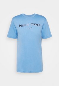 Camiseta de algod�ón azul claro con mangas cortas, que presenta el logo "NIKE PRO" en negro y plata en el pecho. Cuello redondo, ajuste casual.