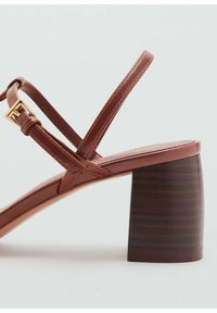 Bruna läderblocksandaler med klack och ett strapsdesign. Har en guldfärgad spänne och en strukturerad träklack. Slät ovansida.