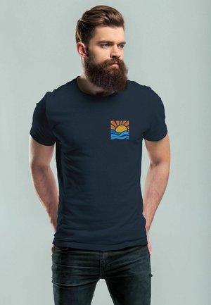 Navy blue cotton t-shirt featuring a colorful graphic of a sun and waves on the left chest area. Fitted design, short sleeves.