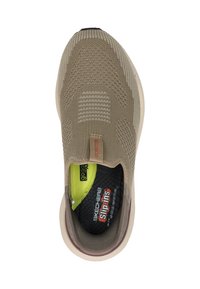 Beige Skechers instapshoe met een gestructureerde brei bovenkant, contrasterende zwarte voering en groene binnenzool. Heeft een gevoerde zool en een oranje logo-label.