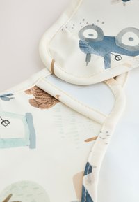 Bavoir pour bébé doux et rembourré avec des motifs d'animaux ludiques dans des couleurs pastel sur un fond clair. Présente un bord incurvé et un matériau imperméable.
