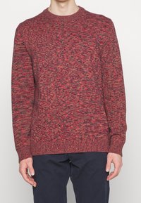 Maglione a maglia rosso e grigio a macchie con scollatura a girocollo, polsini e orlo a costine. Realizzato in un tessuto testurizzato, ha una vestibilità comoda.