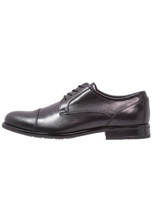 Black leather men's dress shoe with laces, low heel, and stitched cap toe, shown in side profile on white background.