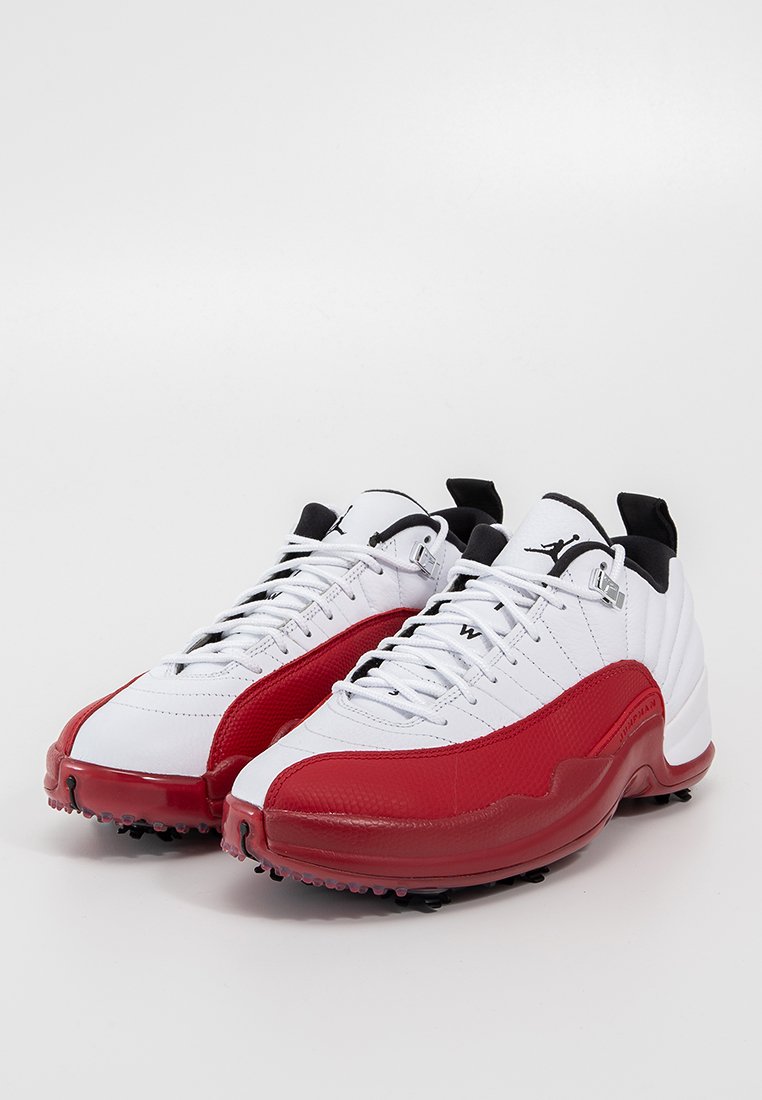 Białe i czerwone buty sportowe z teksturowanym wykończeniem, z czarnymi akcentami, sznurowadłami i wytrzymałą podeszwą zaprojektowaną dla lepszej przyczepności.