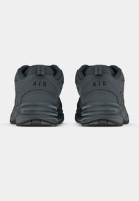 Sötétszürke sportcipők párja hátulról látható, a sarokrészen az "AIR" felirattal és vastag párnázott talppal.