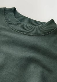 Tmavě zelená mikina se žebrovaným výstřihem do kulata. Materiál má hladkou texturu, s viditelným šitím podél okrajů a švů.