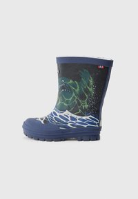 Botte de pluie en caoutchouc bleu marine avec un graphique de monstre vert entouré de vagues d'eau, semelle texturée et rebord supérieur bleu.