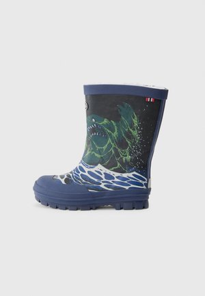 Botte de pluie en caoutchouc bleu marine avec un graphique de monstre vert entouré de vagues d'eau, semelle texturée et rebord supérieur bleu.