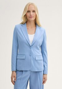 Light blue tailored blazer made of smooth fabric, featuring a notched collar, two front pockets, and two buttons, paired with matching pants.