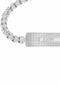 Pulsera de metal tono plata con diseño de cadena y placa rectangular texturizada grabada con el nombre de la marca "JOOP!"