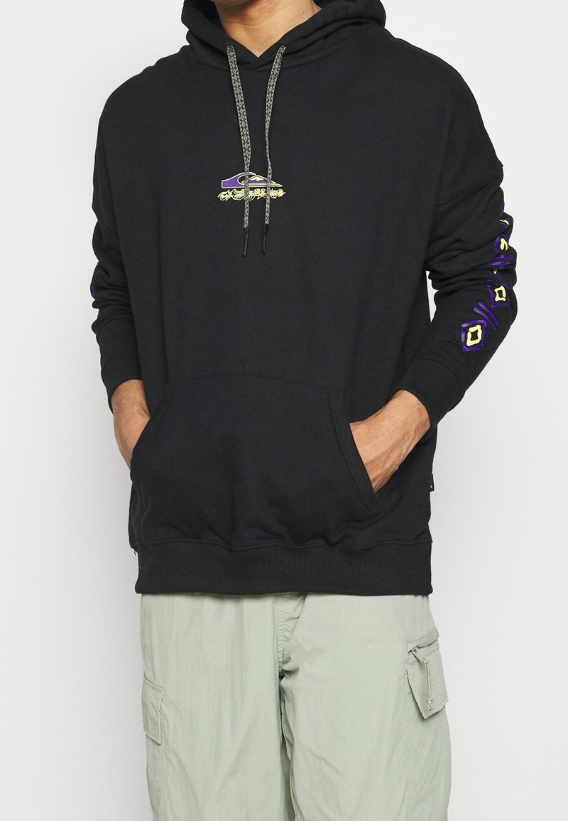 Felpa nera con cappuccio, tasca centrale, e design grafico sul petto. Presenta dettagli viola e oro sulle maniche. Materiale in cotone.