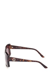Ochelari de soare cu ramă chunky, din material țestoasă, lentile întunecate și un accent metalic cu sigla pe braț. Finisaj lucios și un design elegant, unghiular.