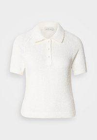 Rövid ujjú, galléros polo póló textúrált off-white anyagból. Három gombos állvány található rajta, valamint bordázott hem. Puha, laza dizájn.