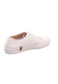 White leather sneaker with a rounded toe, textured surface, stitched details, and a small brown accent on the heel. Laced design.