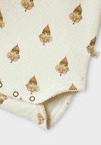 Ribbade tygbodysuit i krämfärg med ett repetitivt mönster av bruna tomtefigurer, med tryckknappar och spetsdetaljer längs kanterna.