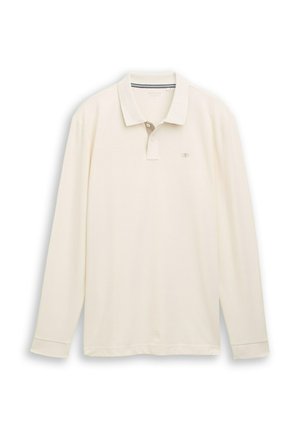 Kreemivärvi pikad varrukad polo särk, valmistatud tekstuursetest kangast. Omab kolme nupuga nöörimist ja logo vasakul rinnal, ribidega krae ja mansetid.